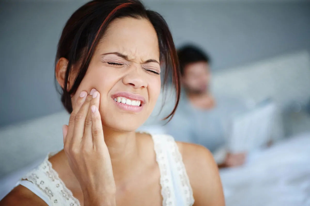 woman holding her mouth in need of an emergency dentist