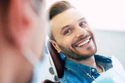 man smiling while talking to Dr. Cox during his first visit to Rugby Dental Arts